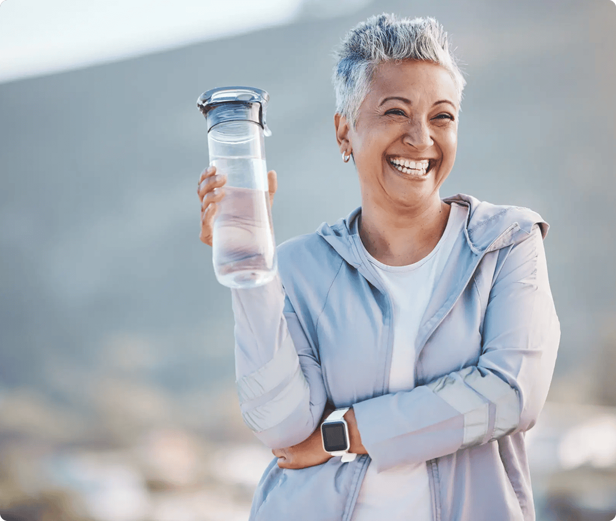 Smiling woman holding a water bottle.