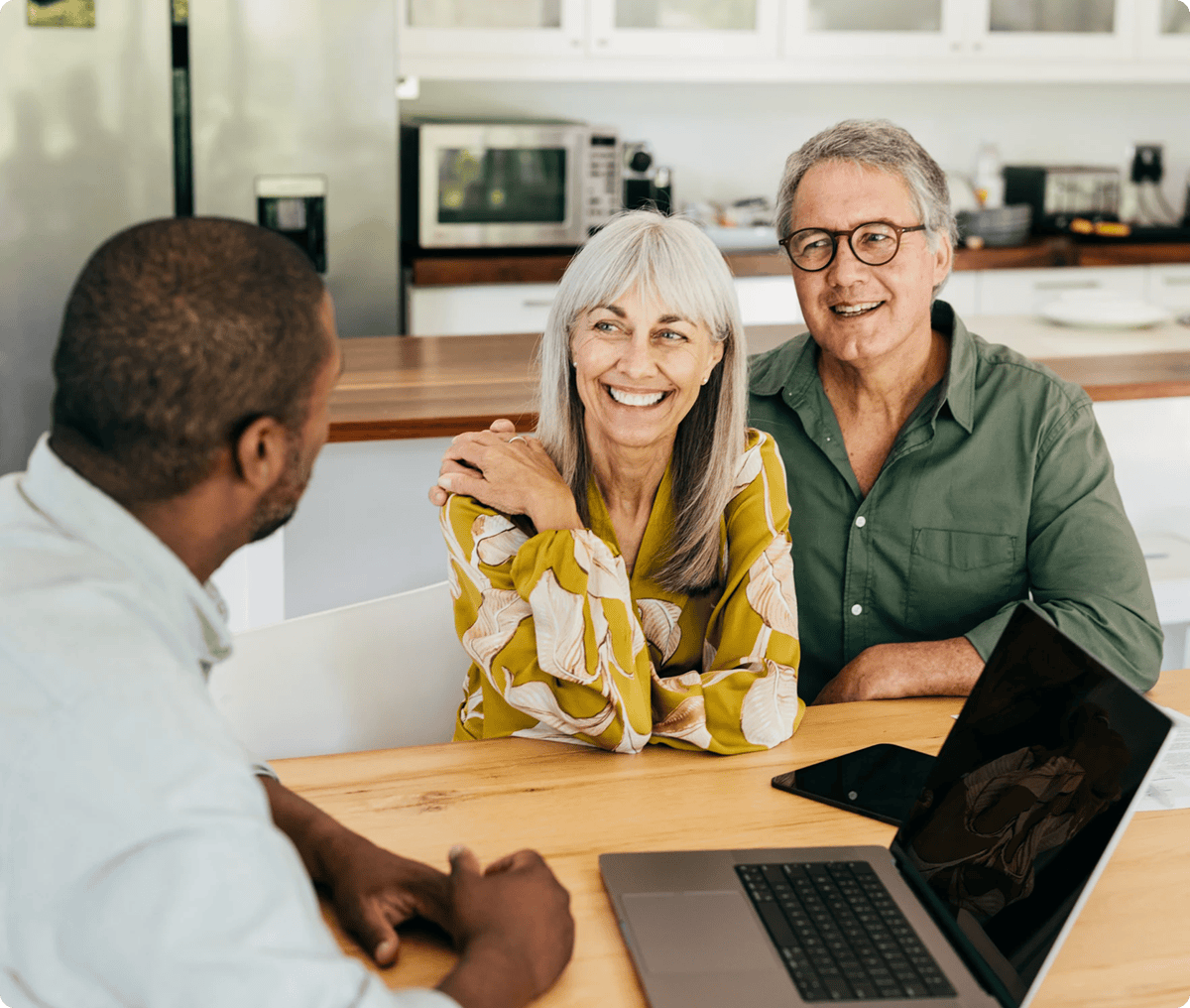 Couple smiling during a meeting with advisor.