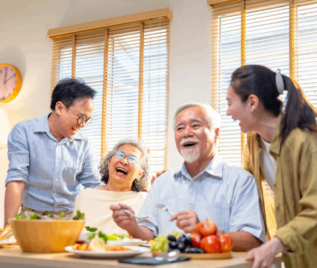Family laughing together at dining table.
