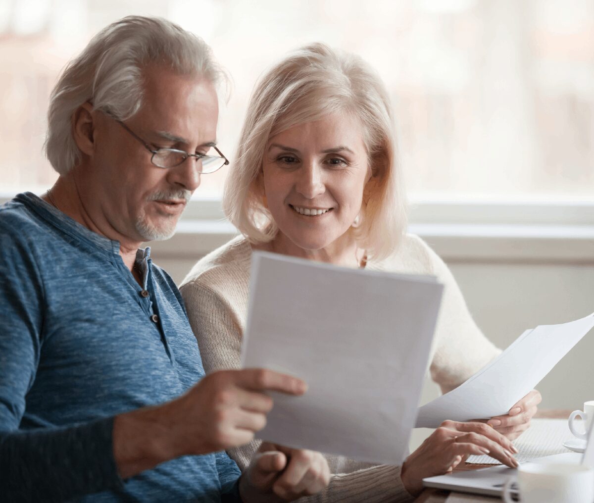 Older couple reviewing documents together at table.