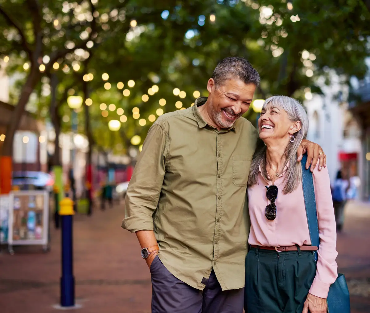 Happy couple walking on a lit street.