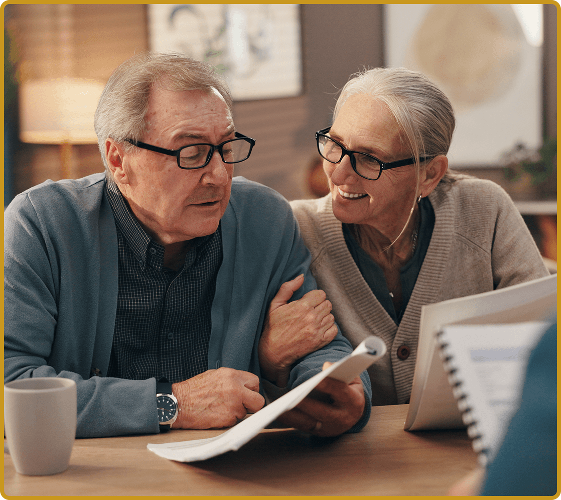 Older adults reading papers at table