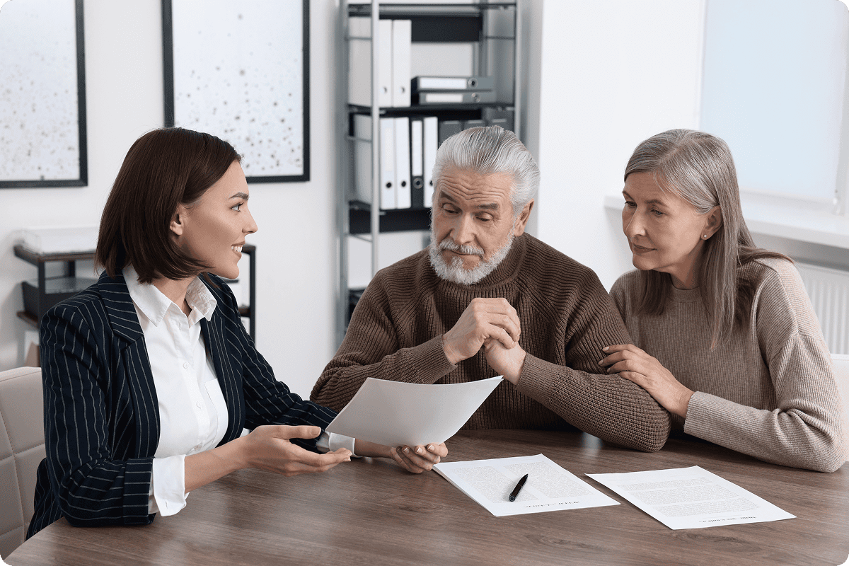 Woman consulting elderly couple with documents.