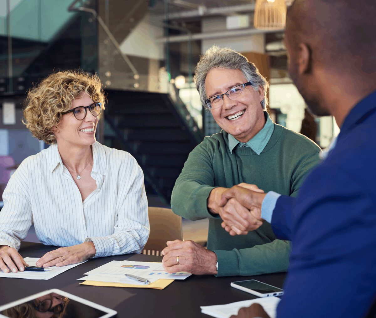 People shaking hands in a meeting.