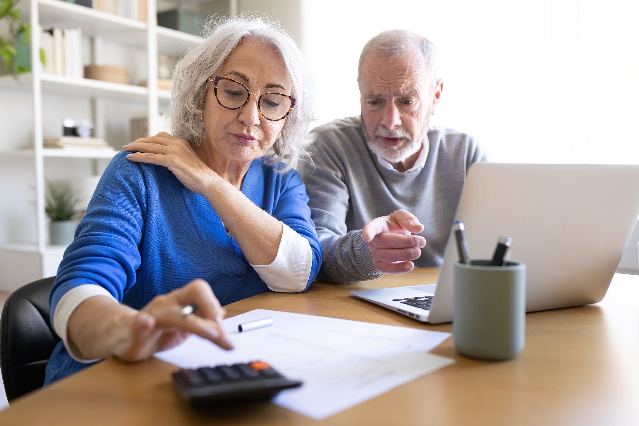 Elderly couple reviewing finances with calculator.
